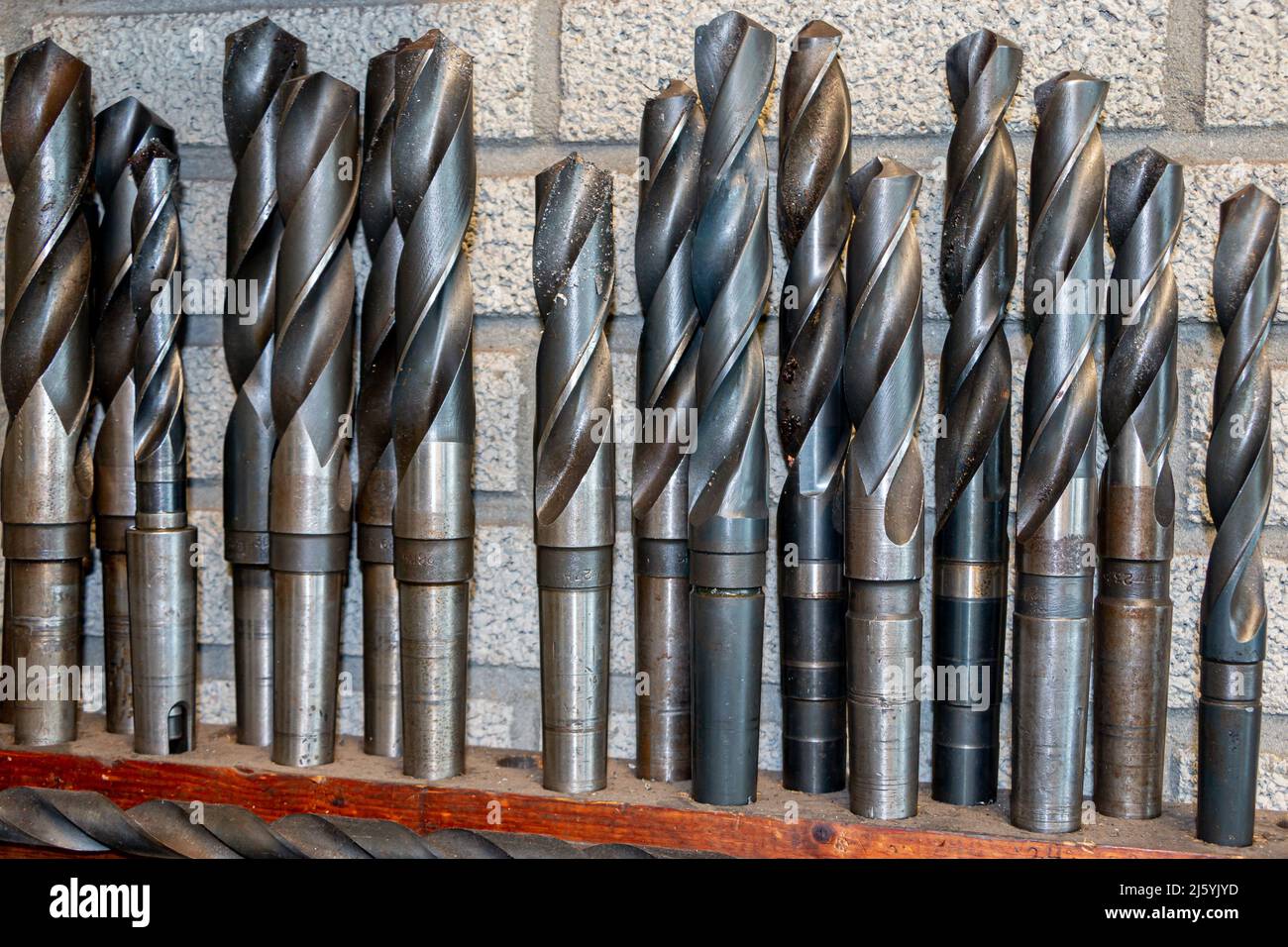 Industrial metal drills in a drill stand for drilling holes in steel and iron material Stock Photo