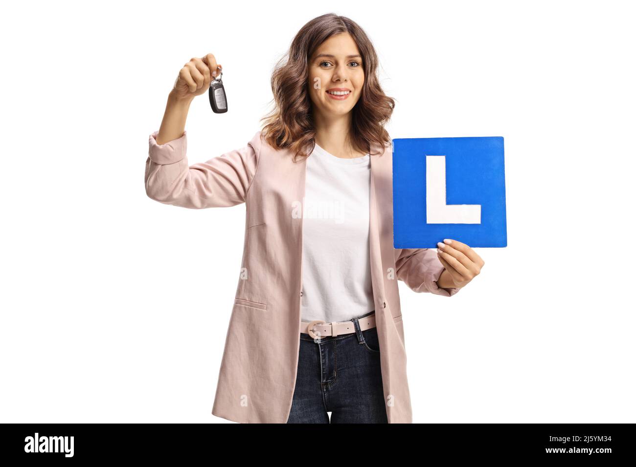Young woman holding car keys and a learner plate for drivers isolated on white background Stock Photo