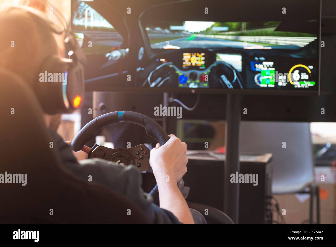 Hands of a Man on a Steering Wheel, While he Plays a Racing Game Stock Photo