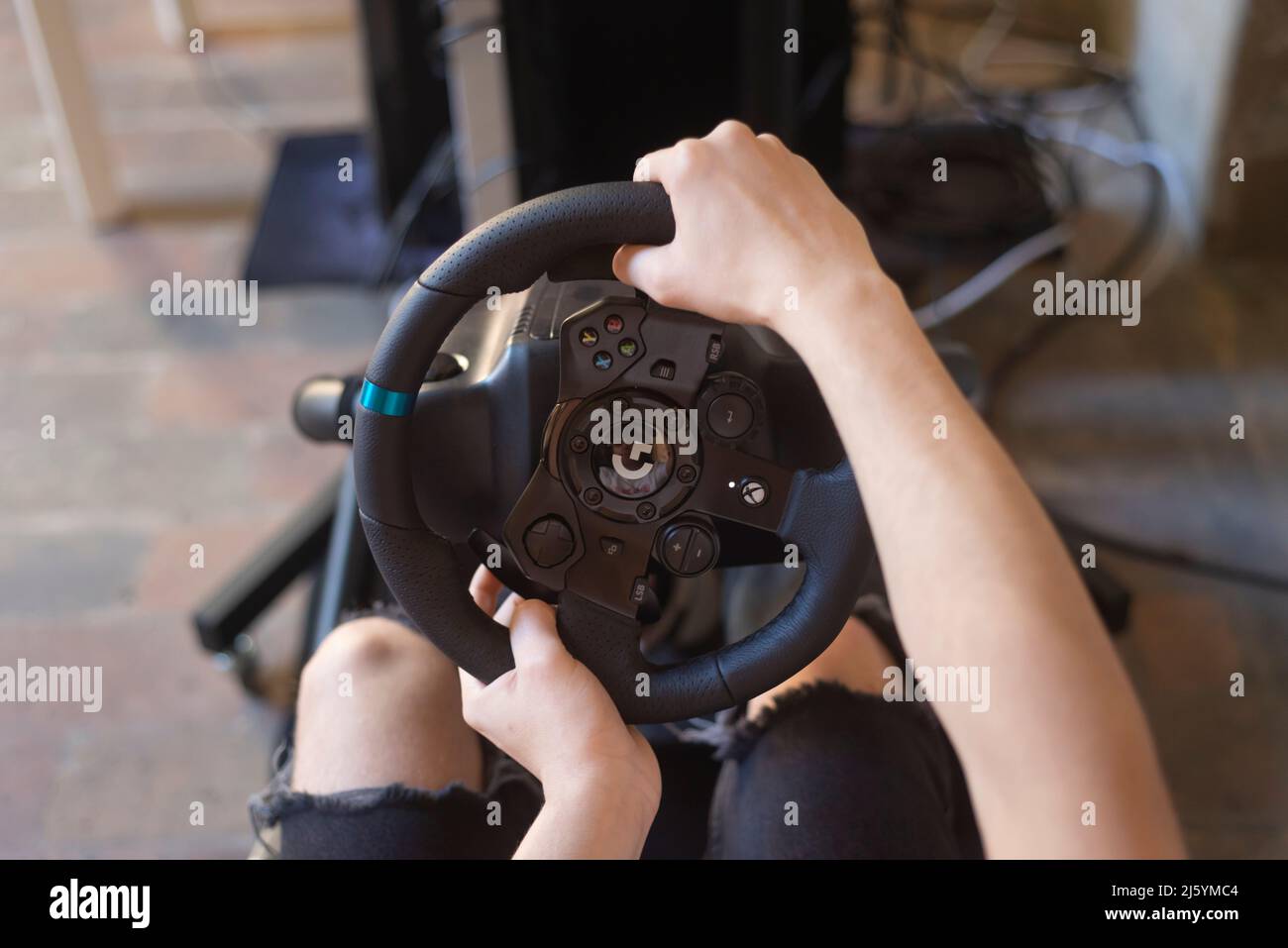 Hands of a Man on a Steering Wheel, While he Plays a Racing Game Stock