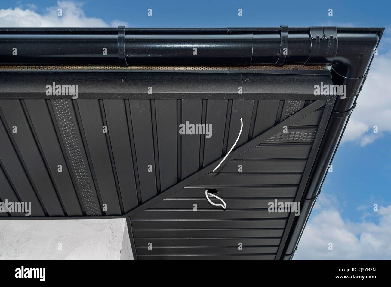 A modern graphite herringbone roof lining is attached to the trusses