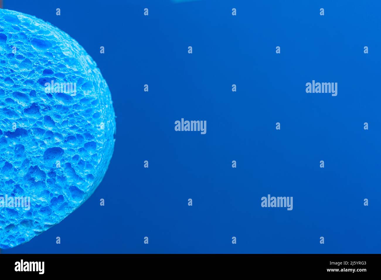 a blue sponge in front of a blue background Stock Photo