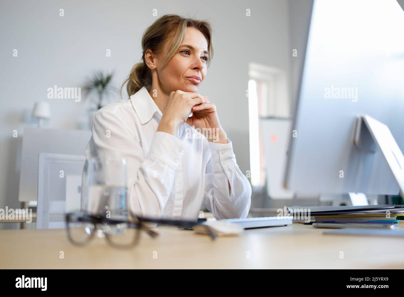 Female office worker looking at the computer screen Stock Photo