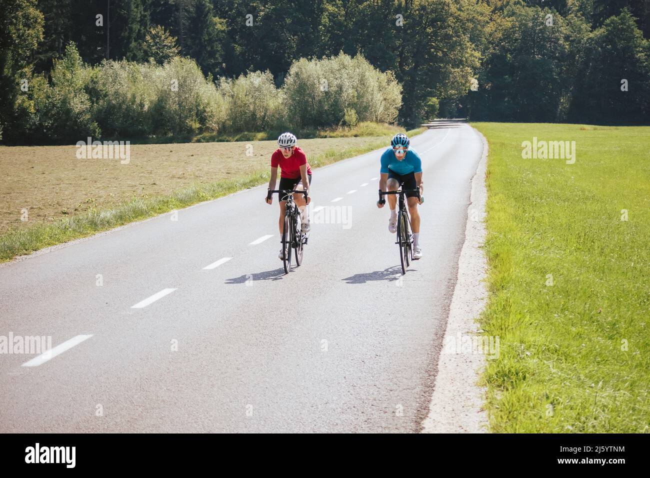 Front view of a woman and man, professional racing bikers in sportswear ...