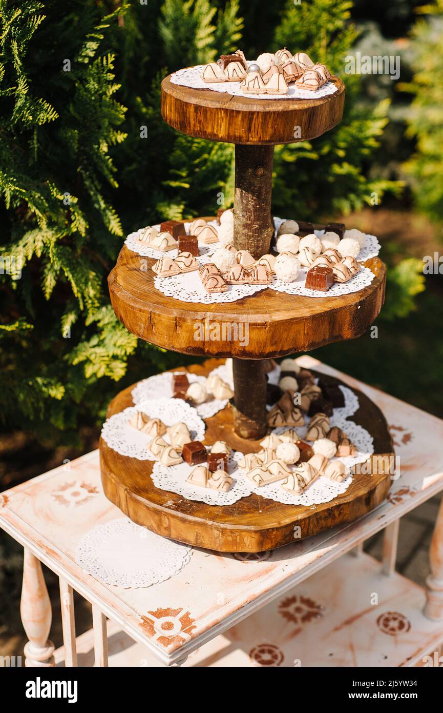 Wooden candy bar at outdoor wedding celebration, catering table in