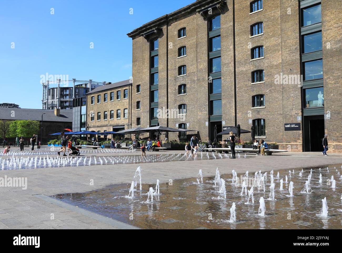 The fountains on Granary Square in spring sunshine, at Kings Cross, north London, UK Stock Photo