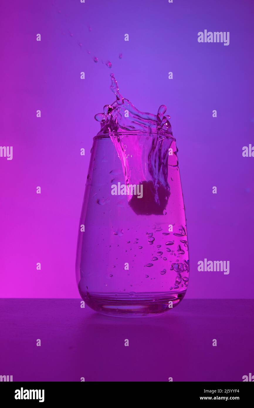 Falling Ice Into A Glass With Clean Drinking Water On A Trendy Ultraviolet Background Stock 4135
