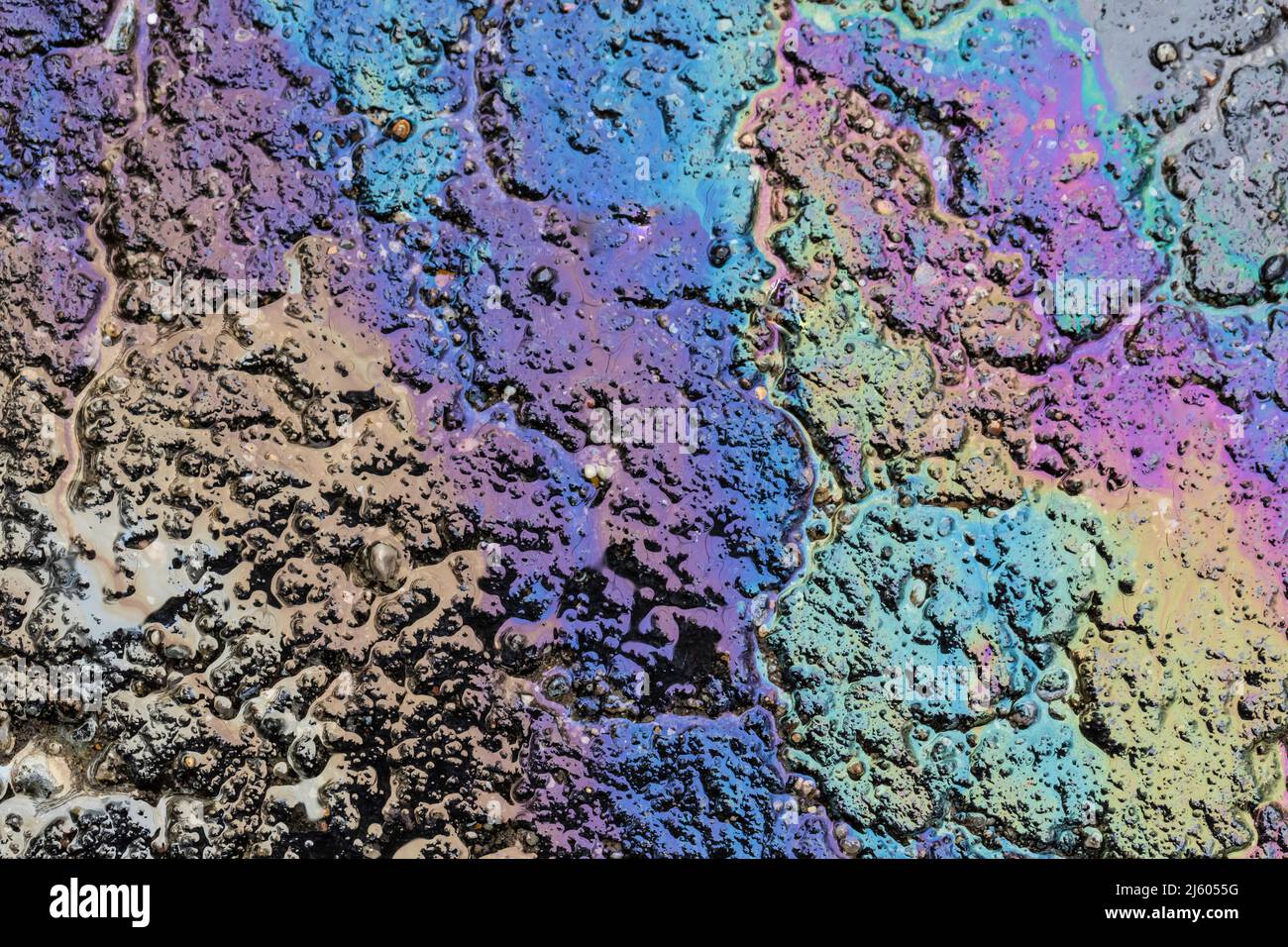 Oil sheen originating from a truck's hydraulic fluid on asphalt in