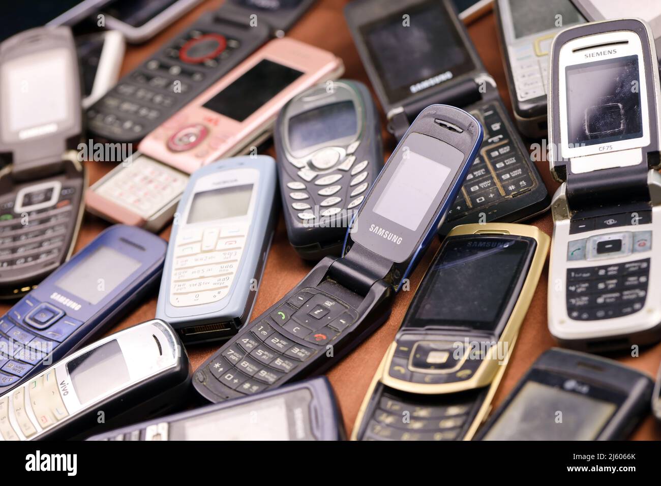 KHARKIV, UKRAINE - DECEMBER 16, 2021: Some old used outdated mobile phones from 90s-2000s period. Recycling electronics in the market cheap Stock Photo