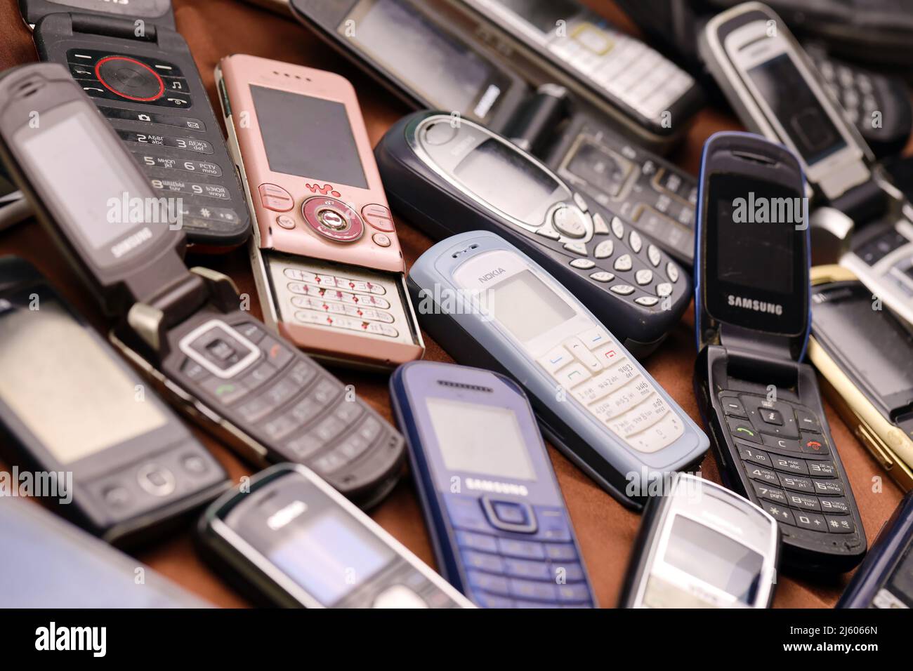 KHARKIV, UKRAINE - DECEMBER 16, 2021: Some old used outdated mobile phones from 90s-2000s period. Recycling electronics in the market cheap Stock Photo
