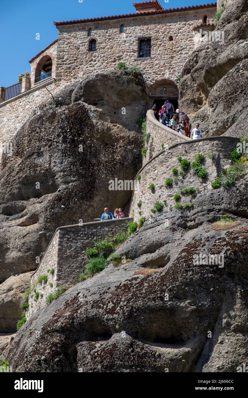 People climbing stairs cut in a rock to Varlaam (Agioi Pantes) Monastery Meteora , Greece Stock