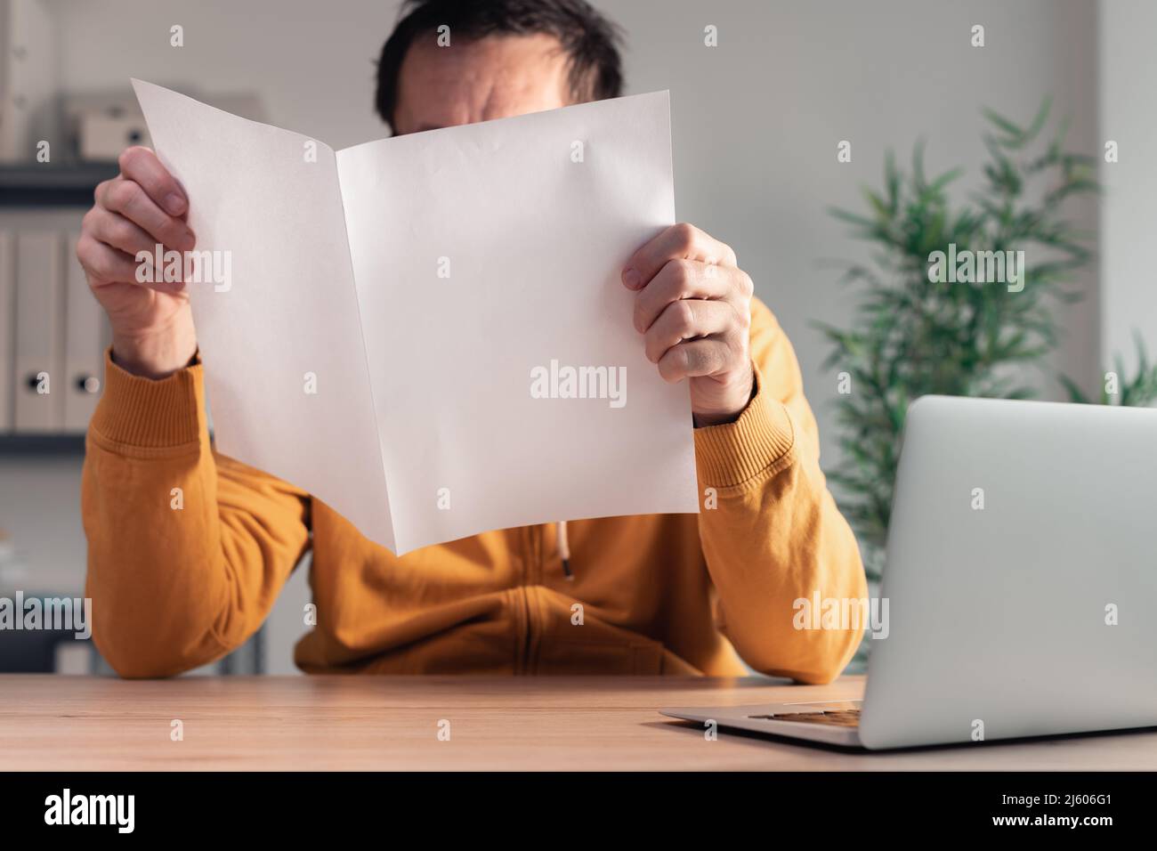 Freelancer with produced business report mockup in home office interior, selective focus Stock Photo