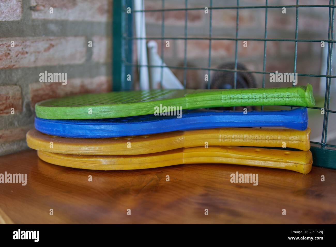 four plastic toy tennis racket on a wooden table. Stock Photo