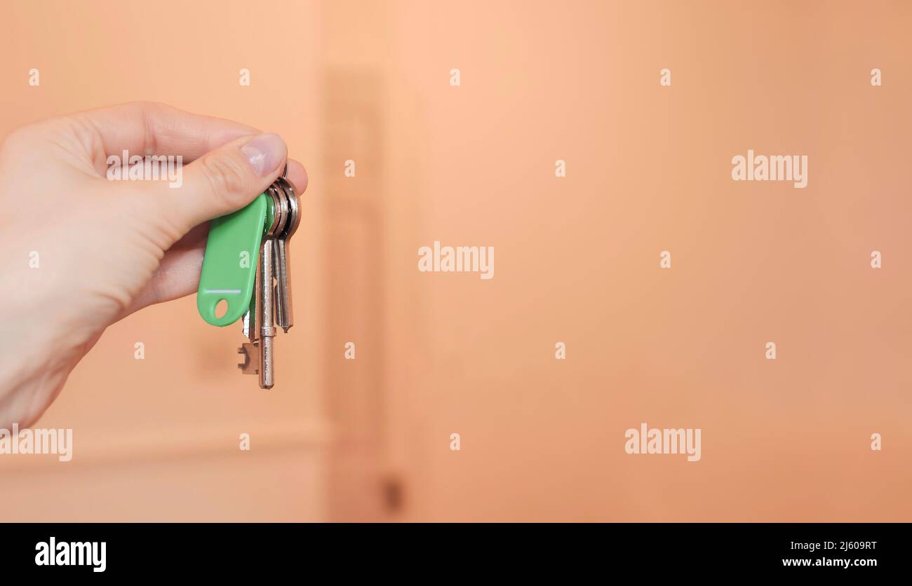 Keys in the woman's hand on the flat background copy space  Stock Photo