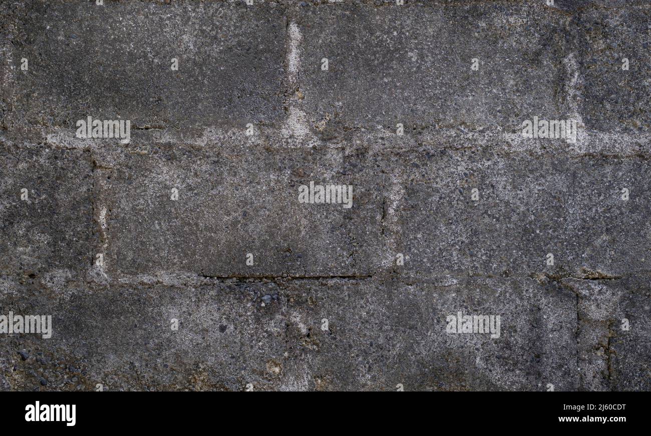 Old dark gray concrete block wall with gray mortar Stock Photo