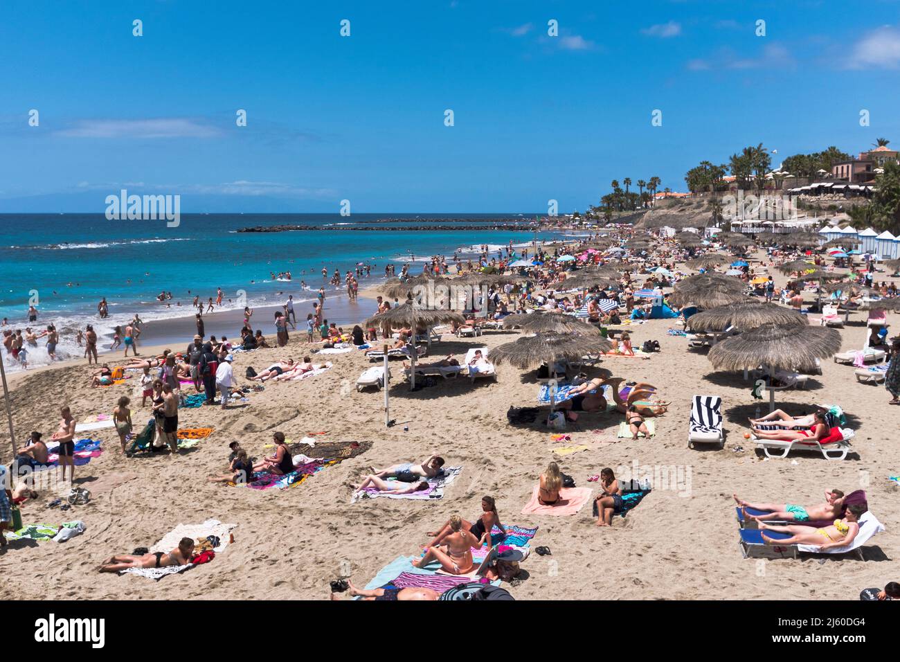 dh Playa del Duque COSTA ADEJE TENERIFE Tourist holiday beach people south coast beaches holidaymakers tourists blue sky Stock Photo