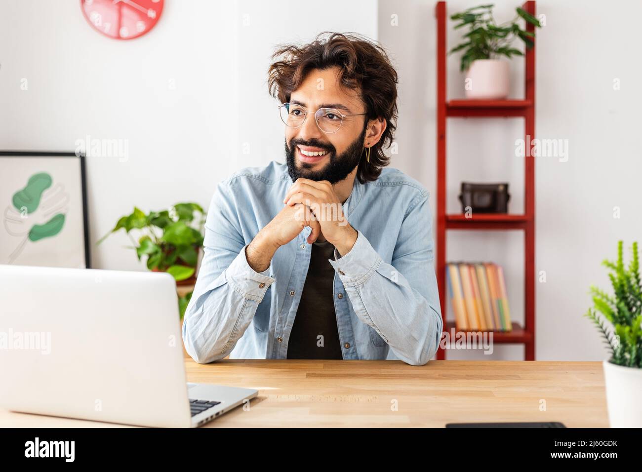 Smiling businessman looking away daydreaming while on a break from work. Stock Photo