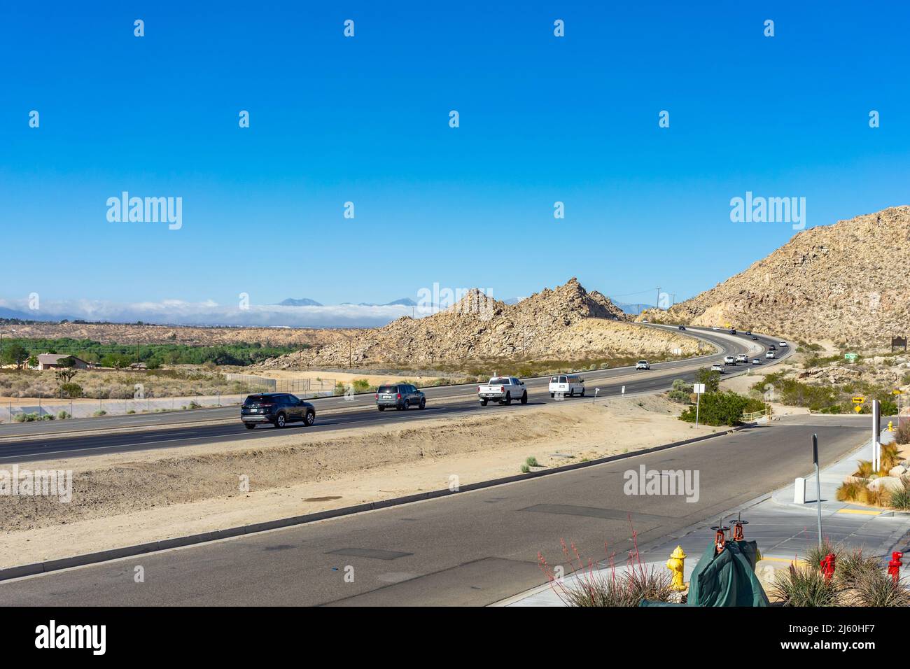 Apple Valley, CA, USA – April 20, 2022: Morning traffic on State Route 18 in the Town of Apple Valley, California. Stock Photo