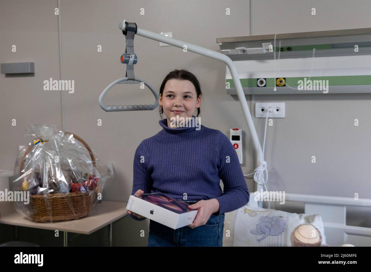 Kyiv, Ukraine. 26th Apr, 2022. Kira Obedinska holds her new iPad present by Ukrainian President Volodymyr Zelenskyy, at the Okhmatdyt National Childrens Specialized Hospital, April 26, 2022 in Kyiv, Ukraine. The girl is one of two orphans evacuated from Mariupol during the Russian attack on the city. Credit: Ukraine Presidency/Ukraine Presidency/Ģ����ý Live News Stock Photo