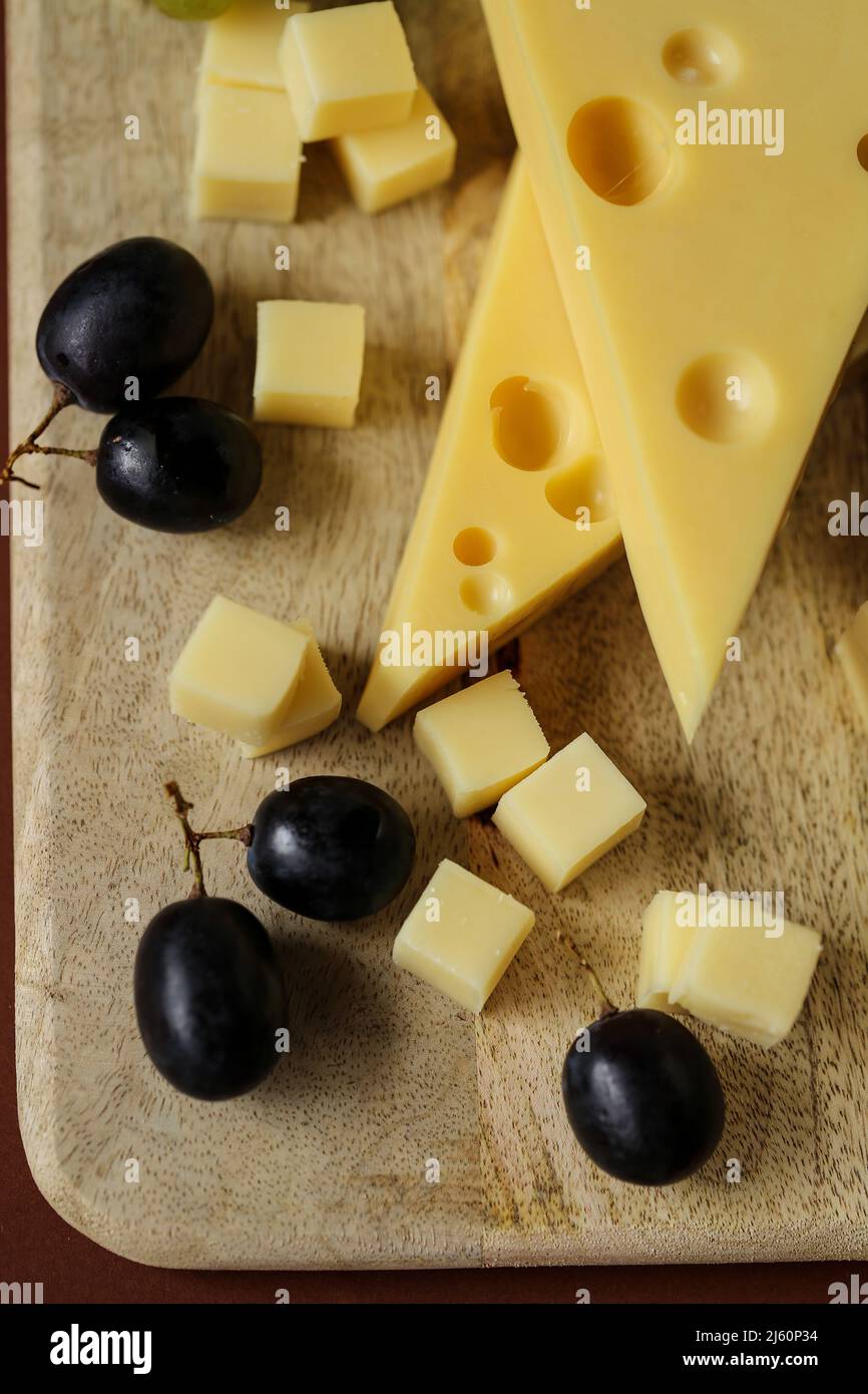 Cheese cut with fruits.Mazdar cheese triangles, gouda cheese cubes and