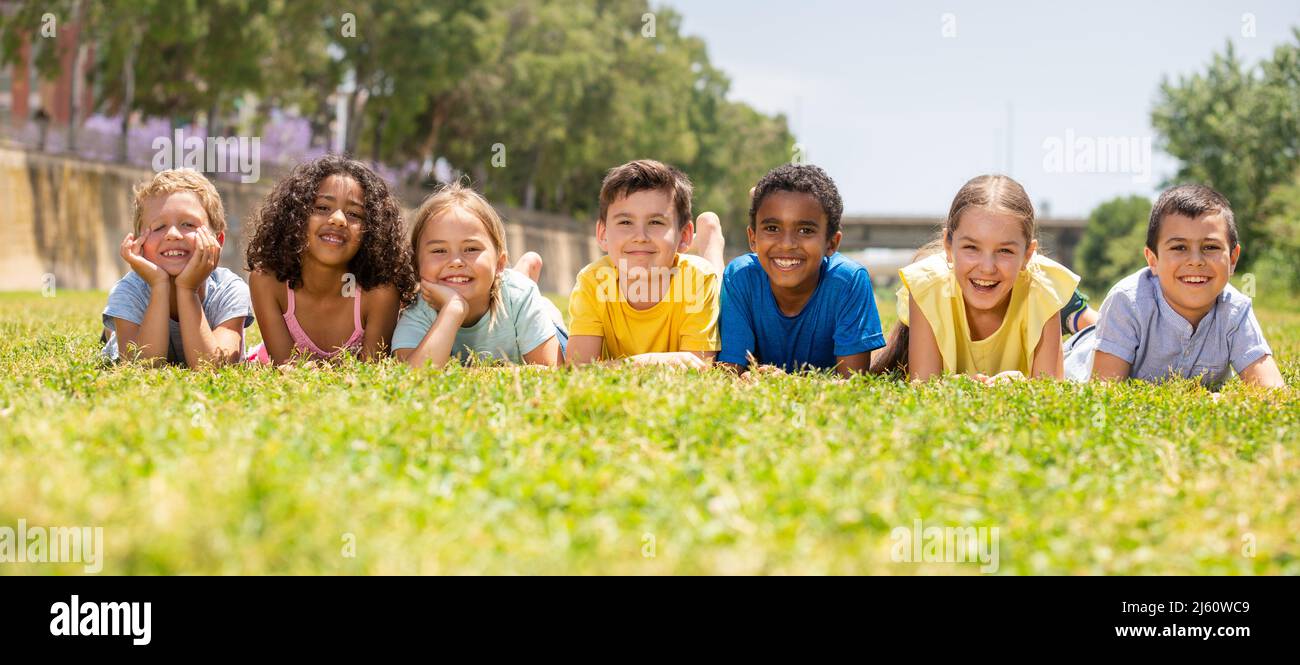 Portrait of smiling children who are posing lying in park Stock Photo ...
