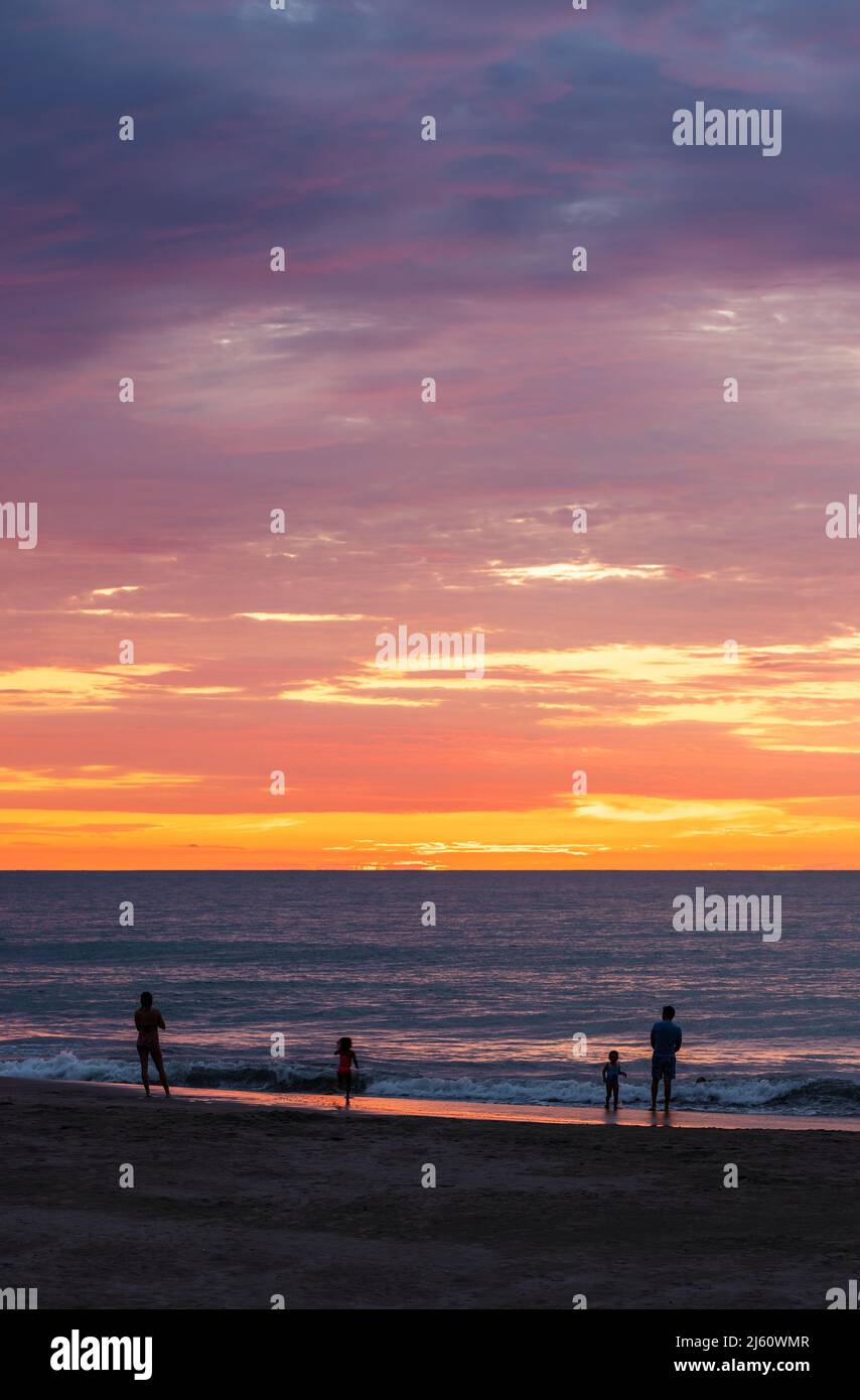 Beach of Same at sunset with people silhouettes and Pacific Ocean sea, Esmeraldas province, Ecuador. Stock Photo