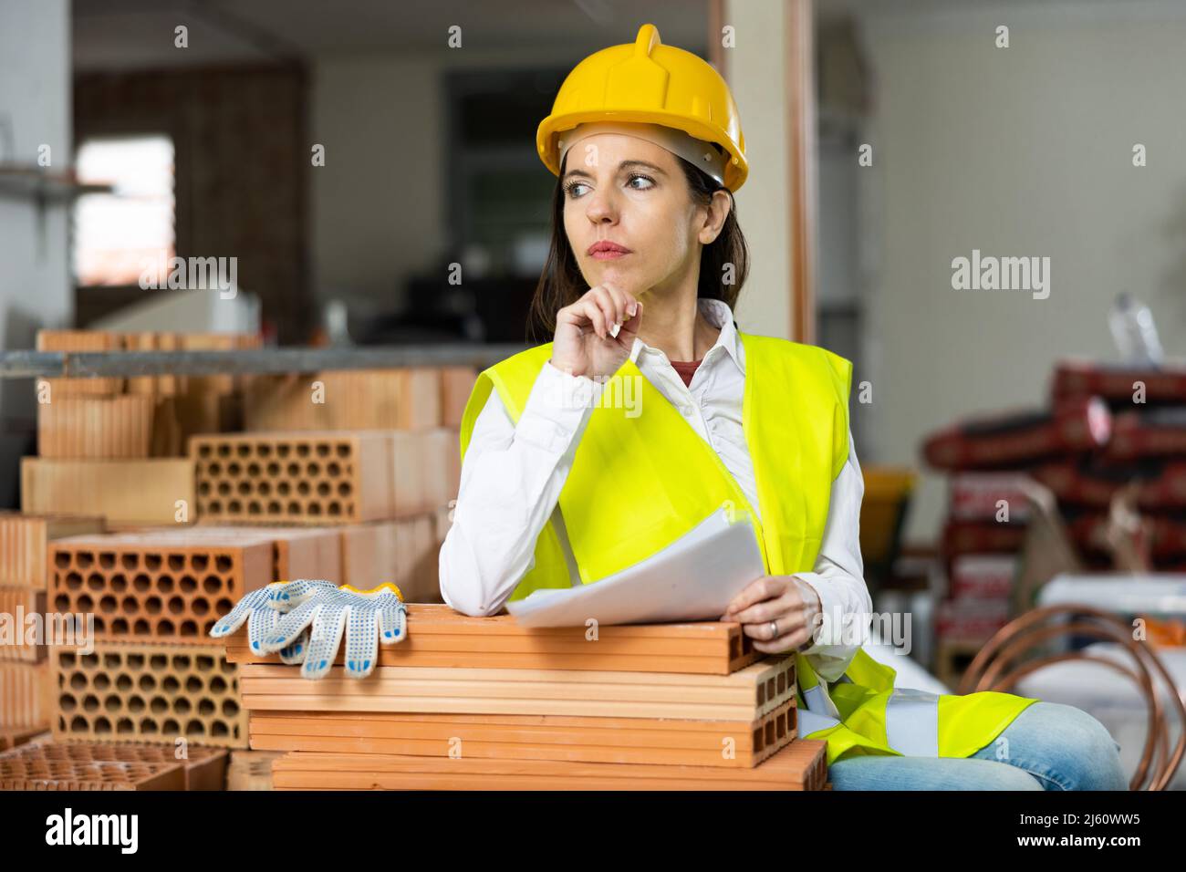 Female supervisor taking notes while inspecting construction site indoors Stock Photo