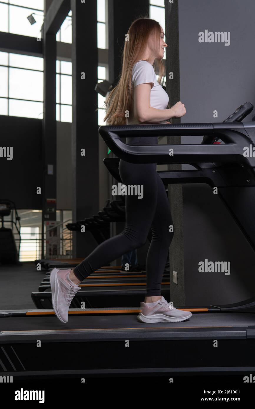 Young woman length indoors treadmill profile full exercise people, for workout fit for caucasian for training recreation, runner athletic. White legs Stock Photo