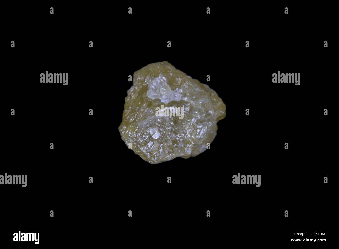 Raw, uncut yellow diamond. 5.7mm diameter, weight 1.9 carats. On Black background. Stock Photo