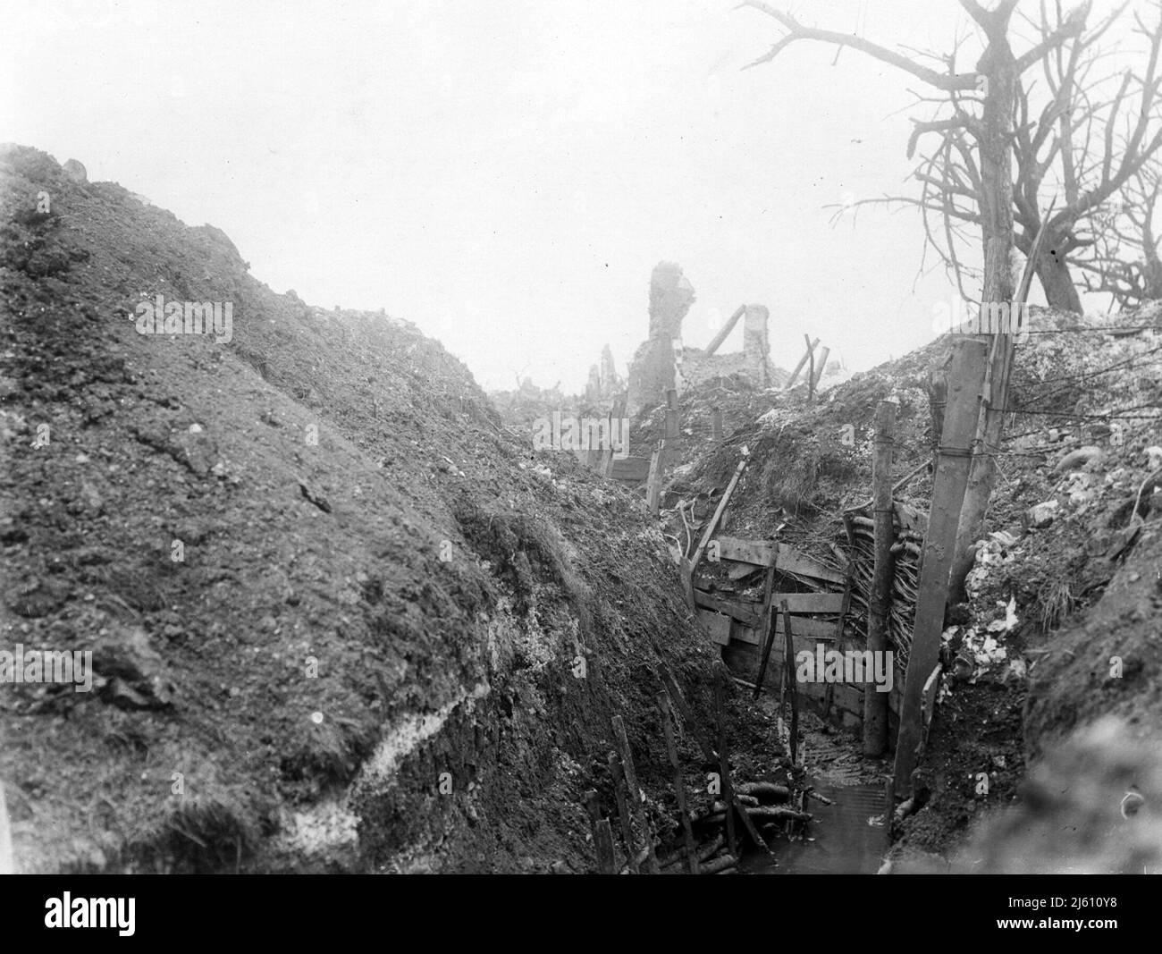 Captured German trench, Gommecourt, France, during World War I. This image shows a typical trench - flooded and extremely muddy. The sides of the trench have been reinforced with large posts, planks of wood and interwoven branches. This photograph gives a very good impression of how high the walls of a trench could be. Soldiers could stand upright in this trench without fear of being seen. Stock Photo