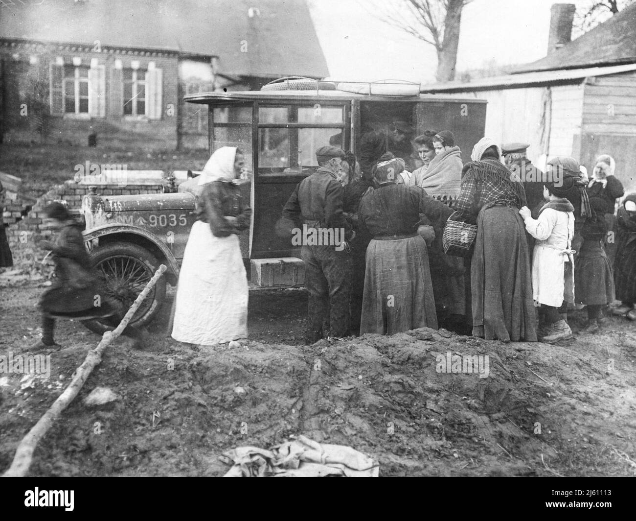 Civilian women clustered around a British army truck that is distributing food to people Stock Photo