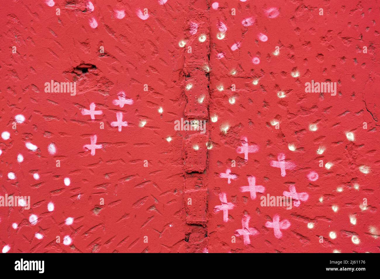spotted red painted rough plaster wall surface. abstract colorful background. Stock Photo