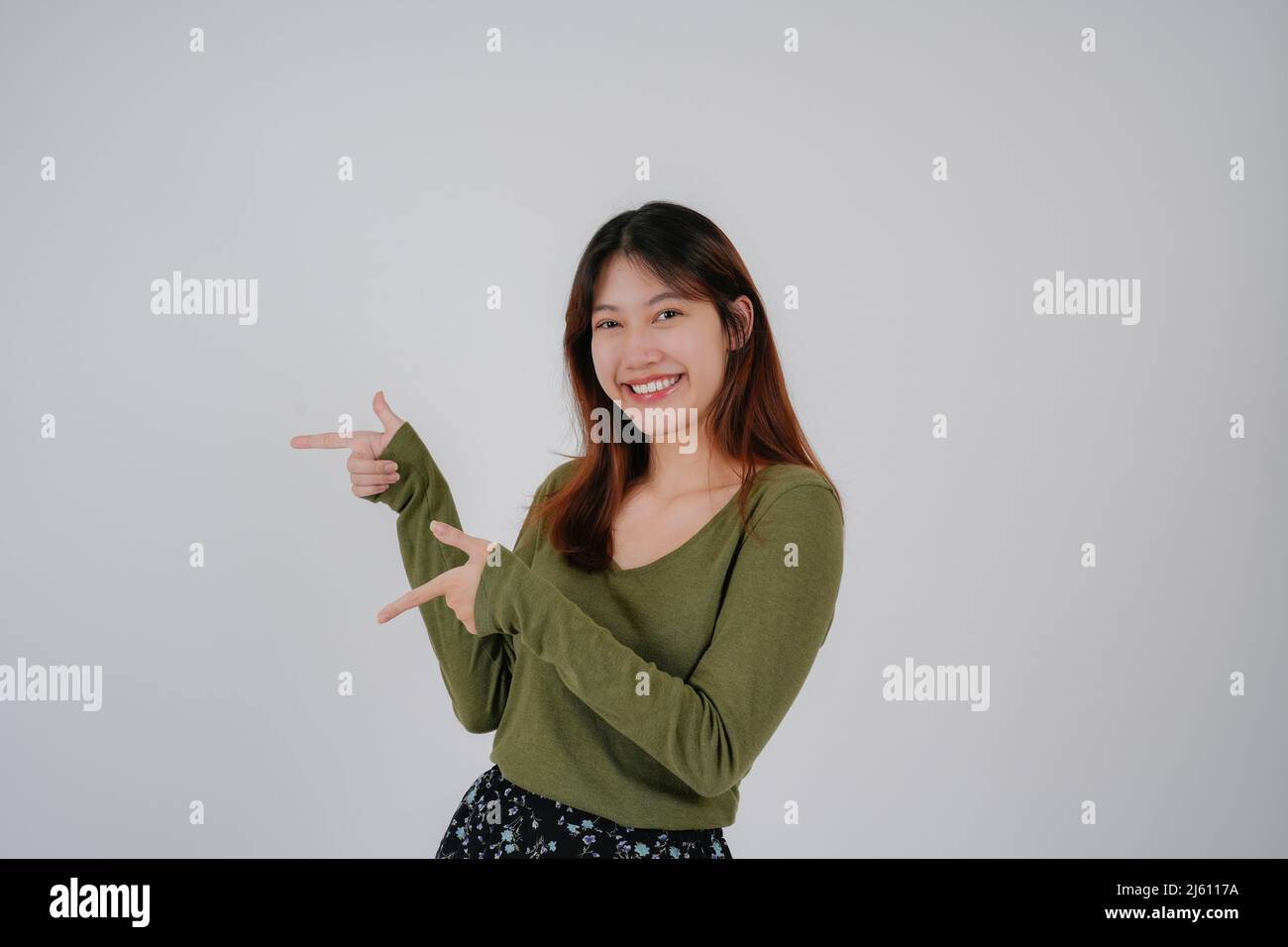 Young asian woman standing over isolated white background happy face smile looking at the camera. Positive person. Stock Photo
