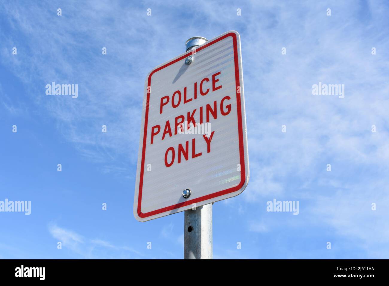 Police Parking Only road sign on pole against blue sky. Stock Photo