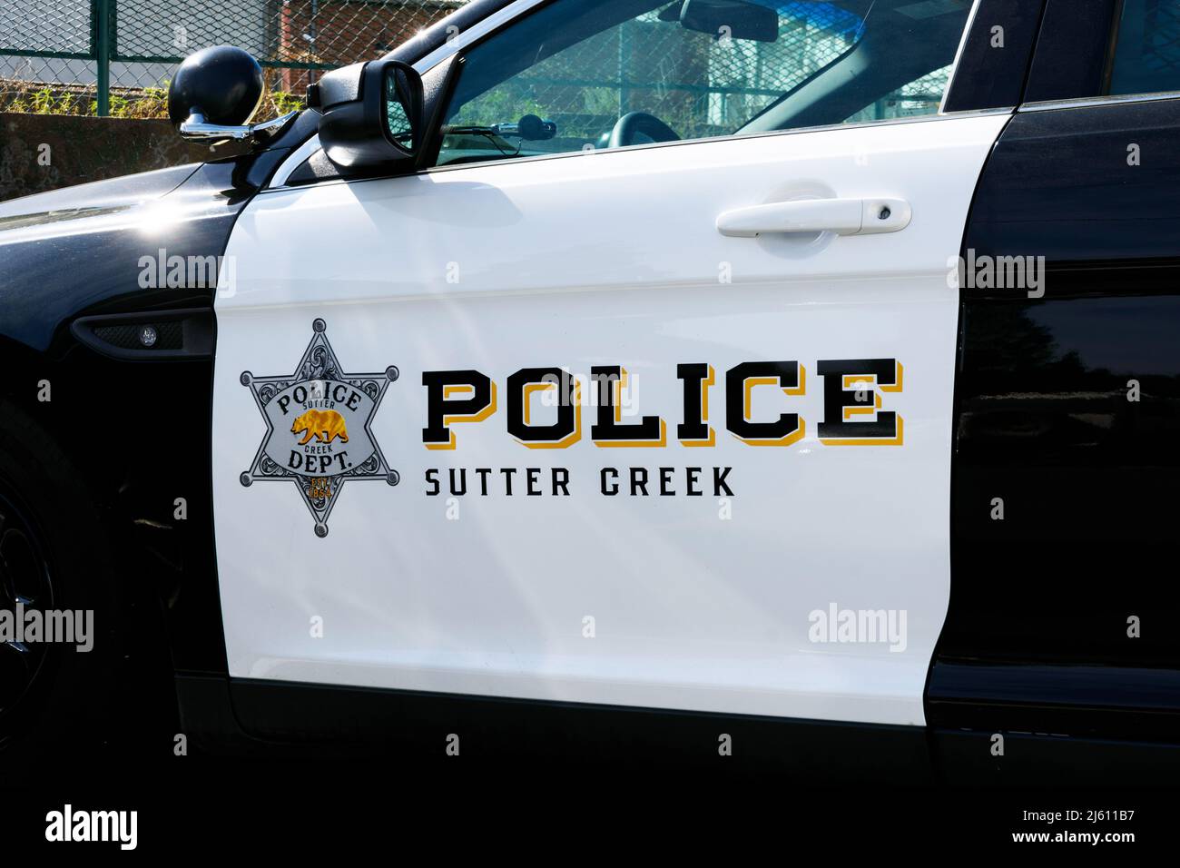 Police sign and Sutter Creek Police Department badge on the side of police vehicle - Sutter Creek, California, USA - 2022 Stock Photo