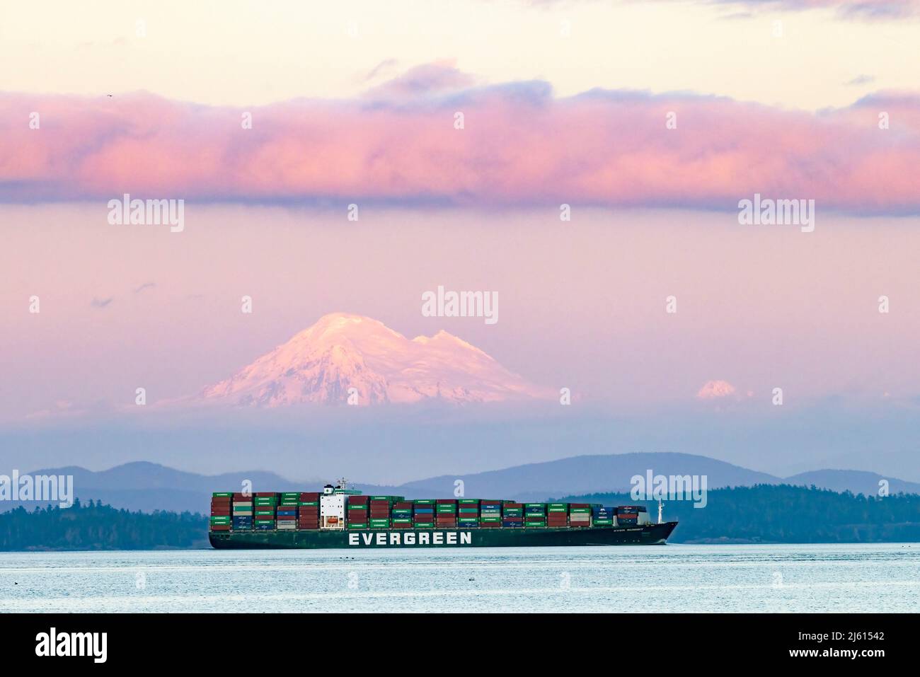 Evergreen container ship in the Haro Strait with Mount Baker in the background. Near Oak Bay, Victoria, Vancouver Island, British Columbia, Canada Stock Photo
