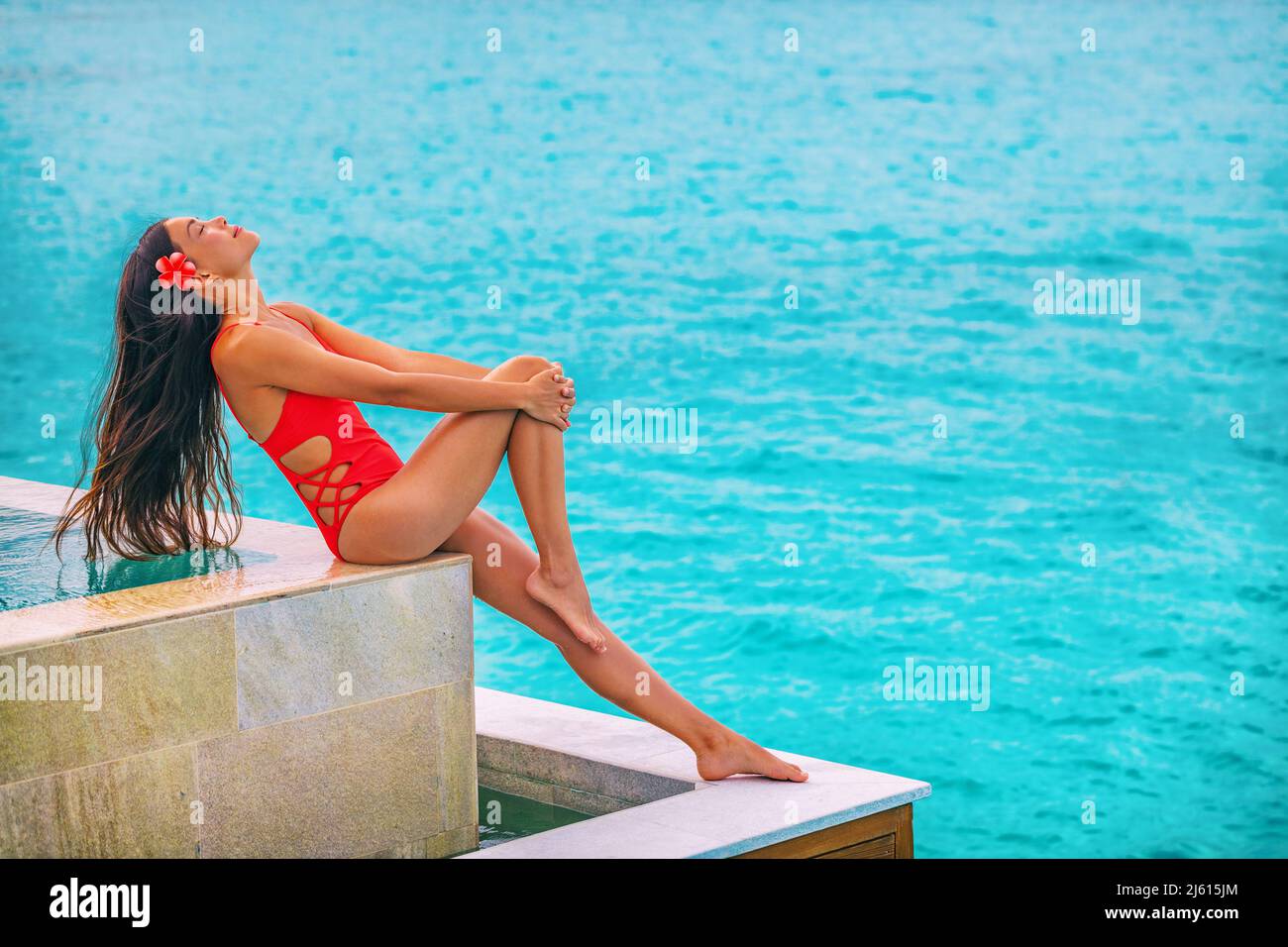 Spa woman after laser treatment with shaved legs. Luxury resort travel vacation natural beauty picture by idyllic overwater bungalow villa. Woman Stock Photo