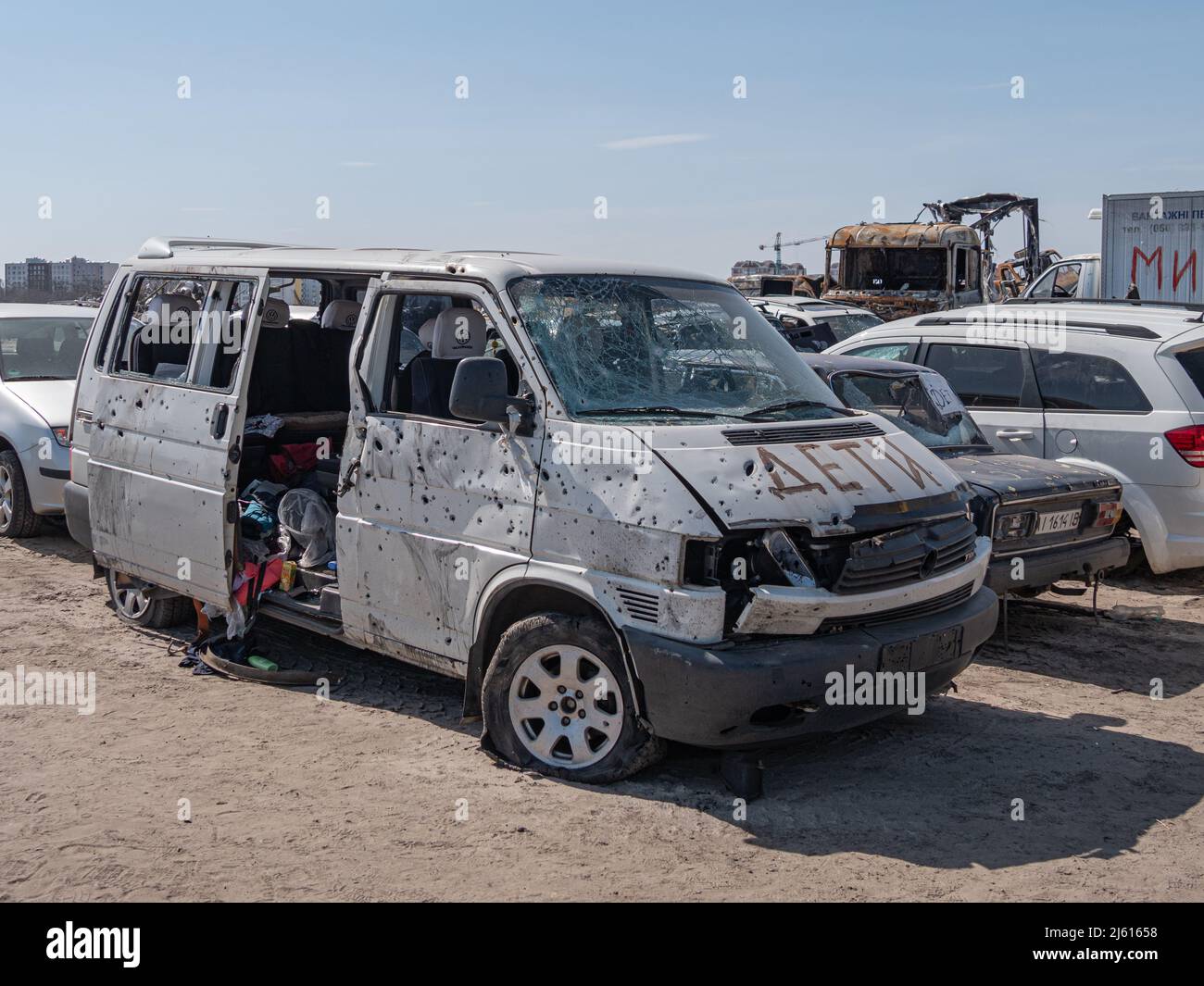 Bucha, Ukraine - April 2022: Minibus with the inscription CHILDREN was shot and slashed with fragments of mines. Dump of shot civilian cars by Russian occupiers in Ukraine. Stock Photo