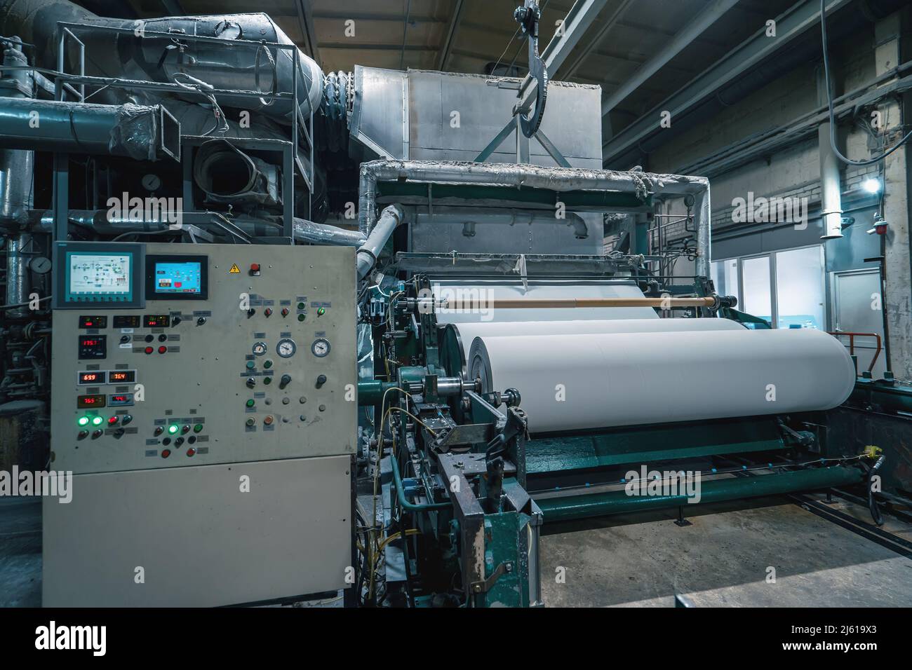 Production machine with rolls of new paper in waste paper recycling