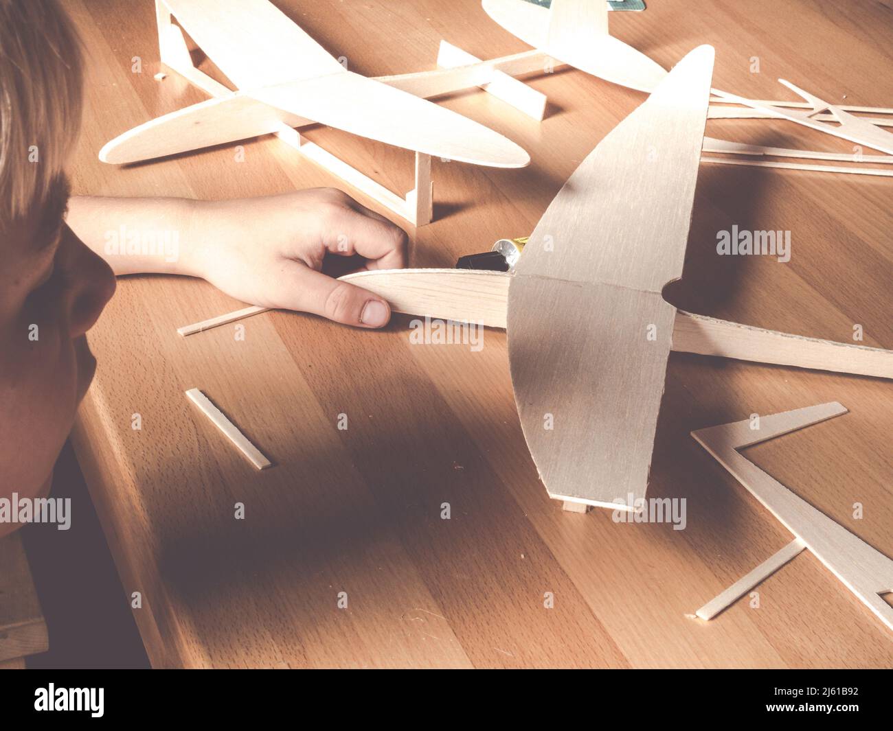 boy holding a wooden plane model; aircraft construction made of balsa wood Stock Photo