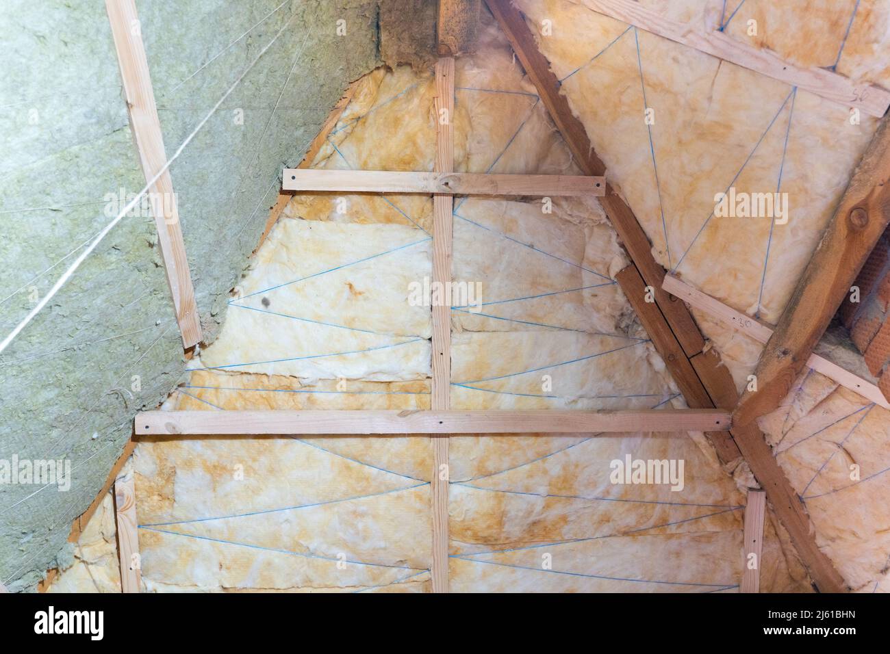 Two layers of insulation on the roof. Gradual laying of yellow glass wool and green mineral wool