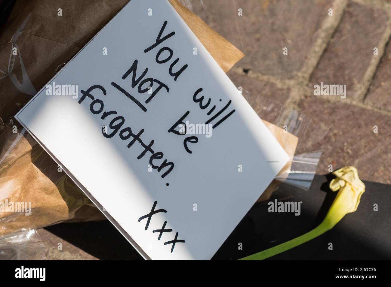 bereavement note which is handwritten on white paper and lying on a ...