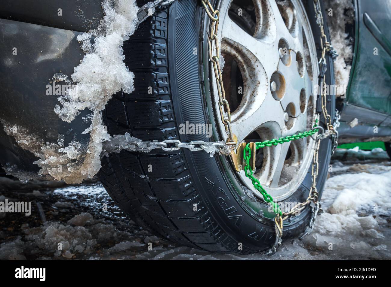 Close-up of snow chain on wheel with friction tire. The concept of safety on snowy roads Stock Photo