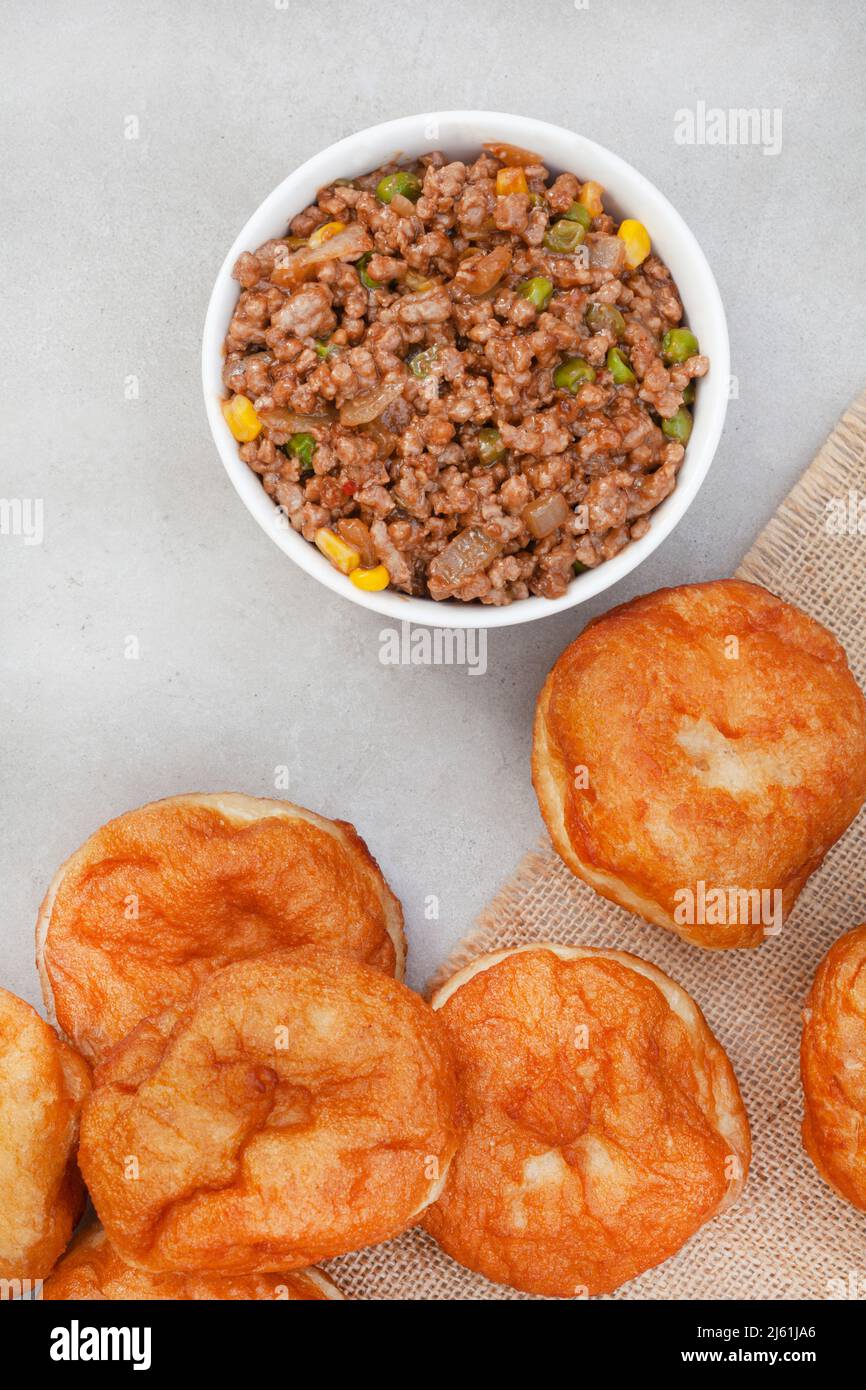 South African vetkoek, deep fried savory dough, on mottled grey