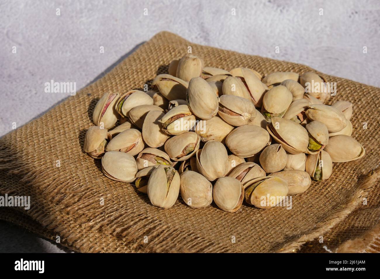 Pistachios in burlap sack on concrete table. Organic pistachios. Vegan