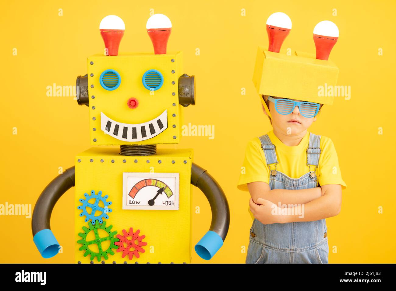 https://c8.alamy.com/comp/2J61JB3/happy-child-with-robot-against-yellow-background-funny-kid-playing-at-home-success-creative-and-innovation-technology-concept-2J61JB3.jpg