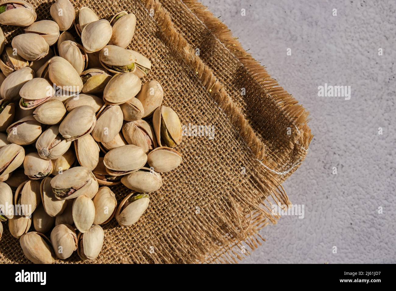 Pistachios in burlap sack on concrete table. Organic pistachios. Vegan