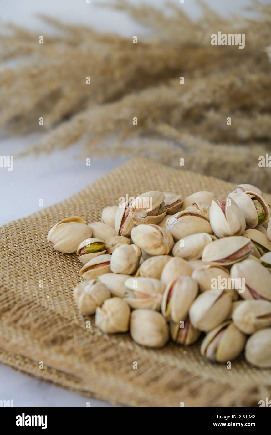 Pistachios in burlap sack on concrete table. Organic pistachios. Vegan