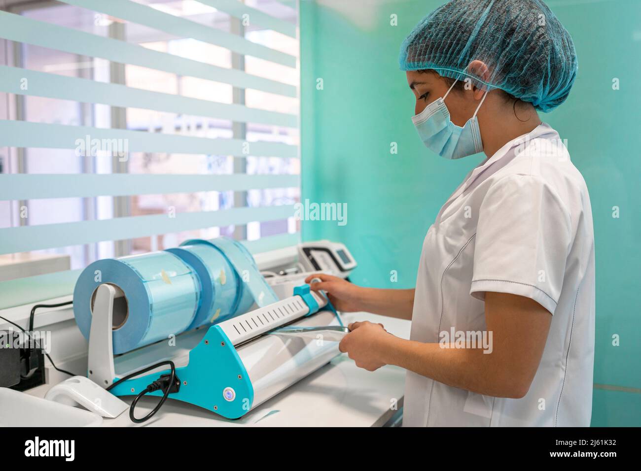 Nurse packing surgical instruments after surgery with vacuum machine at