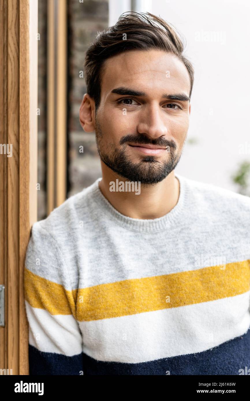 Young man leaning on door frame Stock Photo Alamy